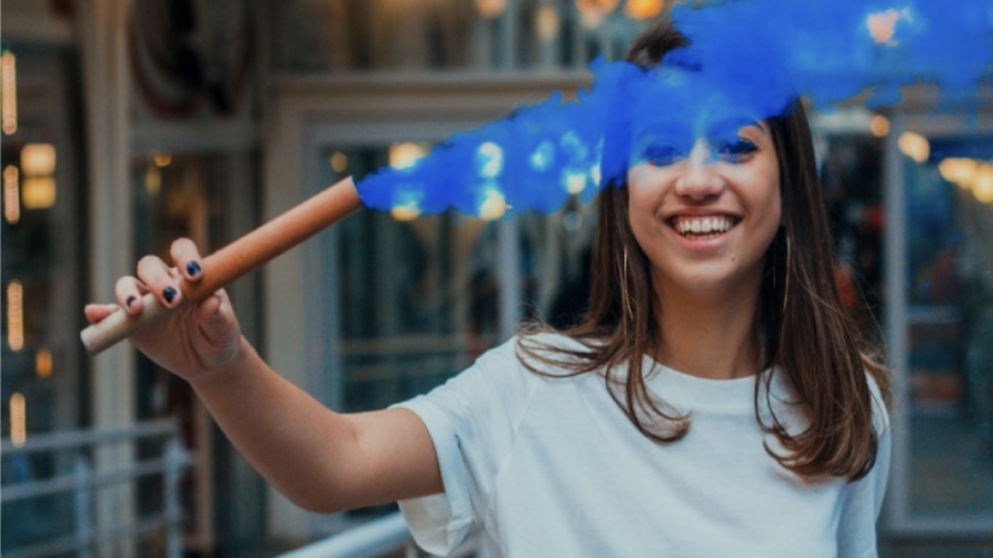 girl holding a stick with blue smoke